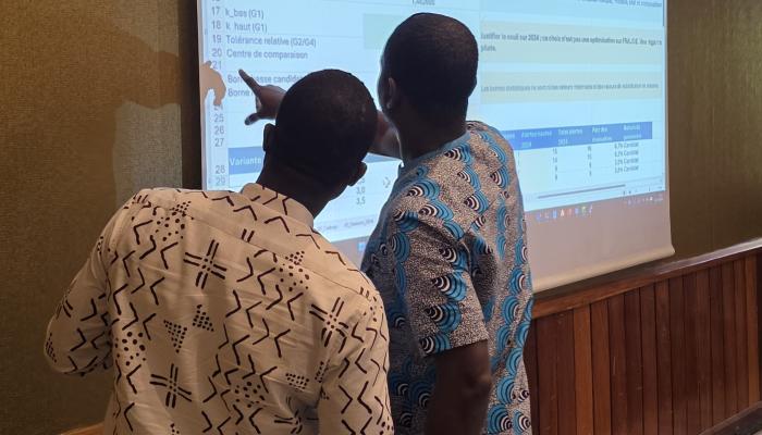 Persons discussing data on screen